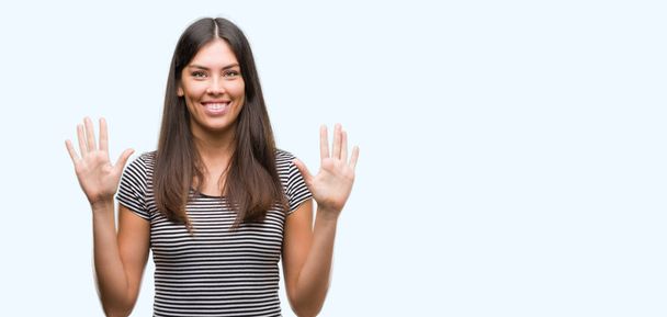 Молода красива іспаномовна жінка, показуючи і вказуючи пальцями номер десять, посміхаючись впевнено і щасливо
. - Фото, зображення