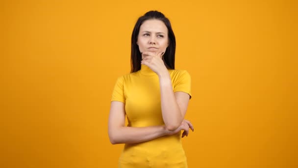 Thinking woman on yellow background - Footage, Video