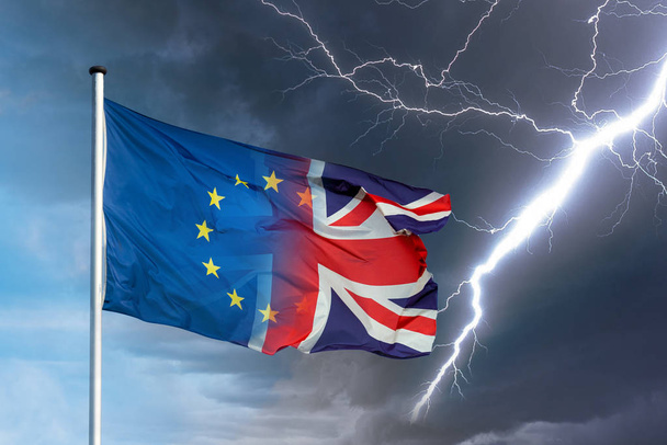 Merging european and british flag with lightning bolt in front of dark clouds in sky as a symbol for the Brexit - Фото, зображення