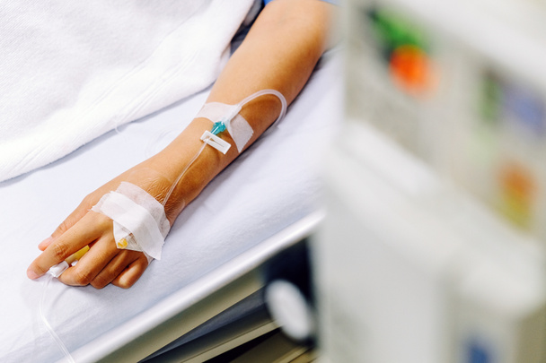 Imagen de cerca del goteo intravenoso en la mano del paciente en el hospital
. - Foto, imagen