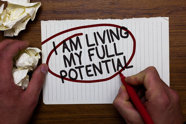 Text sign showing I Am Living My Full Potential. Conceptual photo Embracing opportunities using skills abilities Hand hold paper lob and red pen red circled black words on white paper - Photo, Image