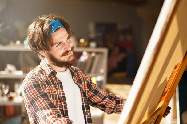Male Bearded Artist Holding Canvas - 写真・画像
