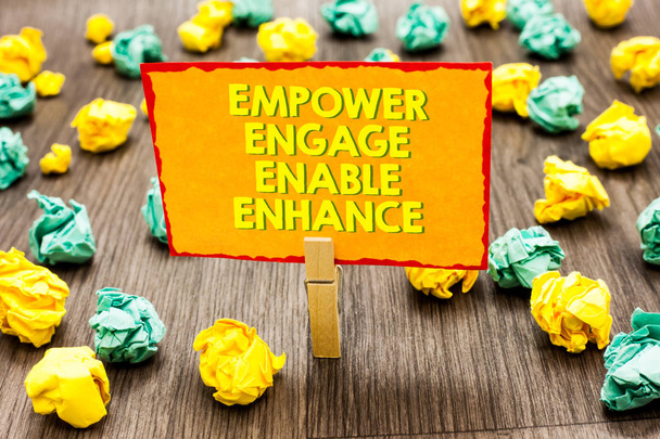 Tekst pisma Empower Engage Włącz Ulepsz. Znaczenie pojęcia inicjacji Leadership motywacja zaangażowania spinacza przytrzymaj napisane żółte strony lobs kolorowy papier na drewnianej podłodze - Zdjęcie, obraz