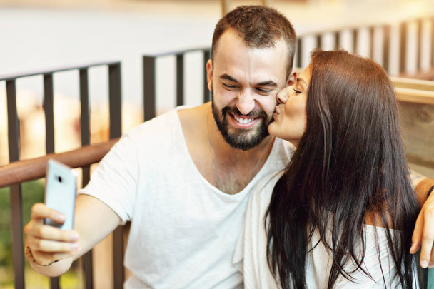 Romantische paar dating in café en het gebruik van smartphone - Foto, afbeelding