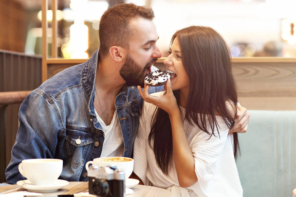 Couple romantique sortir ensemble dans un café et manger un beignet
 - Photo, image