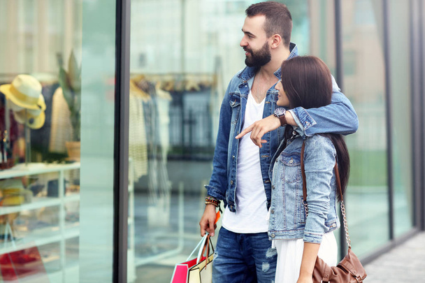 Portret szczęśliwej pary z torbami na zakupy po zakupach w mieście - Zdjęcie, obraz