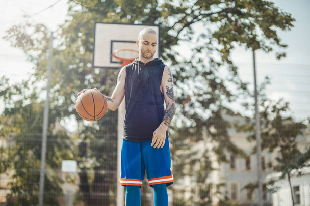 Bald attractive man playing basketball. - Fotoğraf, Görsel