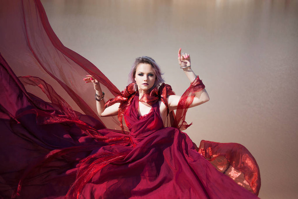 Lady in red. Young beautiful woman in red flying dress - Foto, imagen