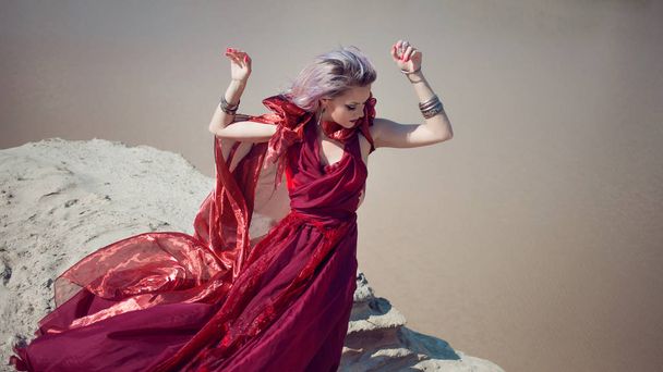Lady in red. Young beautiful woman in red flying dress - Foto, afbeelding