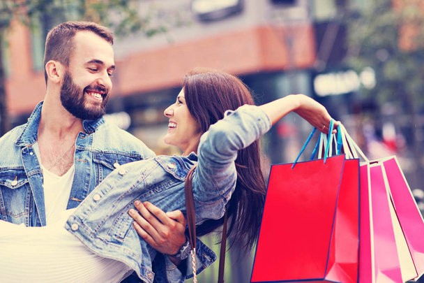 Alışveriş yaptıktan sonra alışveriş torbalarıyla mutlu bir çiftin portresi. - Fotoğraf, Görsel