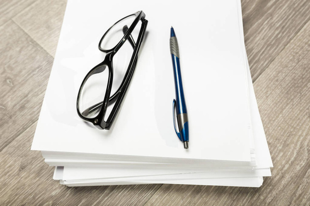 Blank notebook and pencil with glasses on wooden table - Photo, image