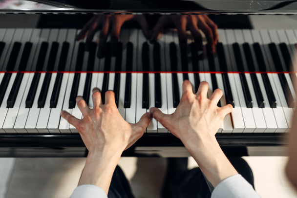 Mani di pianista maschile sulla tastiera del pianoforte a coda, vista dall'alto. Musicista che pratica la melodia al royale, strumento musicale classico
 - Foto, immagini