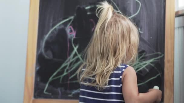 little girl draws chalk on a blackboard - Footage, Video