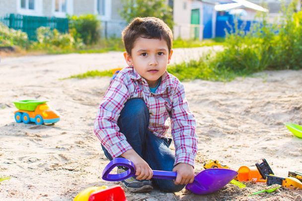 мальчик 4 лет, играющий с песком
 - Фото, изображение