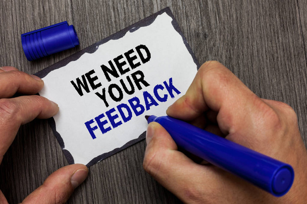 Handwriting text We Need Your Feedback. Concept meaning Give us your review thoughts comments what to improve Gray wooden deck hand hold black marker written black lined sticky note - Photo, Image
