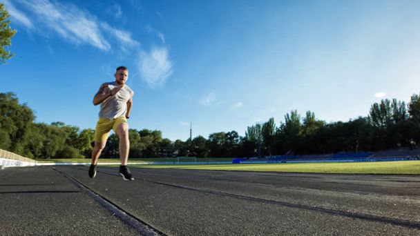 Urheilullinen mies juoksee kilparadalla
 - Valokuva, kuva