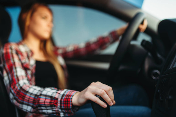 Young woman drives a car. Female person in vehicle, driving automobile concept - Fotó, kép