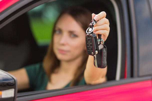 Beautiful girl with keys from car in hand, concept of buying a new car, feelings of joy from shopping - Photo, Image
