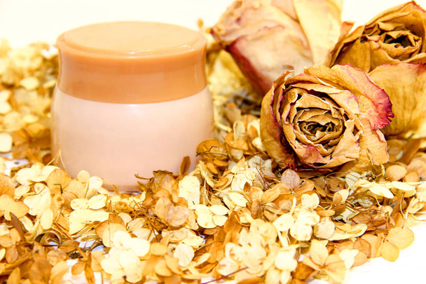 un pot de crème parmi les pétales éparpillés d'hortensia et de fleurs de rose fond
 - Photo, image