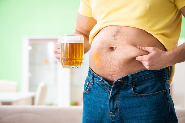 Толстяк с ожирением держит пиво в диете - Фото, изображение