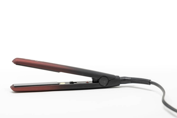 A debadged pair of hair straighteners set against a white background - Photo, Image