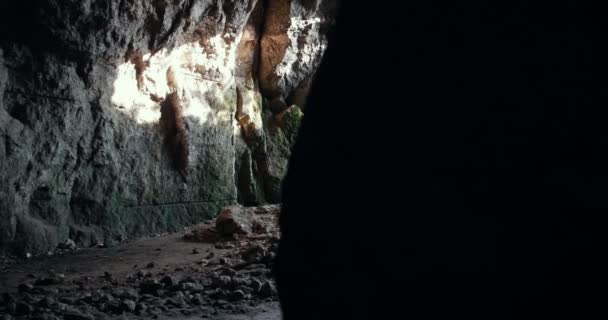 Młodzi przyjaciele w kaskach eksploruje ciemne jaskini z latarką - Materiał filmowy, wideo