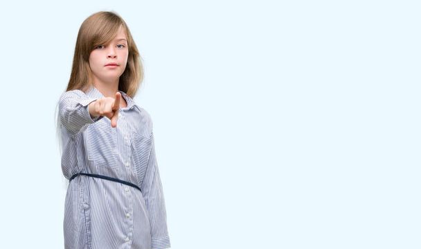 Jovem criança loira vestindo camisa azul apontando com o dedo para a câmera e para você, sinal de mão, gesto positivo e confiante da frente
 - Foto, Imagem