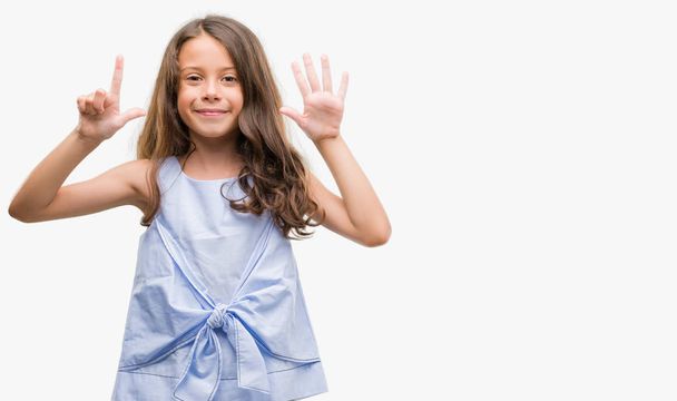 Morena chica hispana mostrando y señalando hacia arriba con los dedos número siete mientras sonríe confiado y feliz
. - Foto, imagen