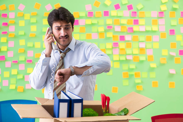 Мужчина собирает свои вещи после увольнения в офисе с мужчиной - Фото, изображение