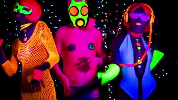 Mujeres y chico en máscara de gas en ropa fluorescente bajo luz negra UV
 - Metraje, vídeo
