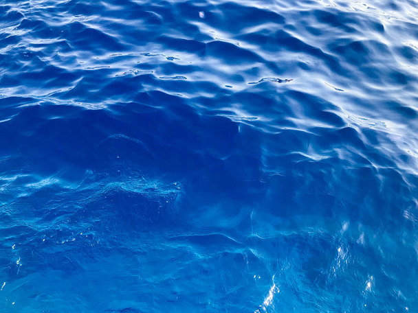 The texture is a saturated blue saline pure azure wet beautiful light sea water with waves. The background. - Photo, Image