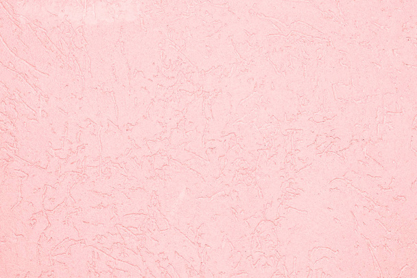 the pink texture of the surface of the wall covered with decorative plaster of the woodworm type, close-up architecture abstract background - Photo, image