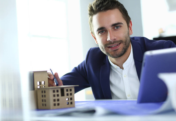 Businessman holding house miniature on hand standing in office - Foto, Imagem