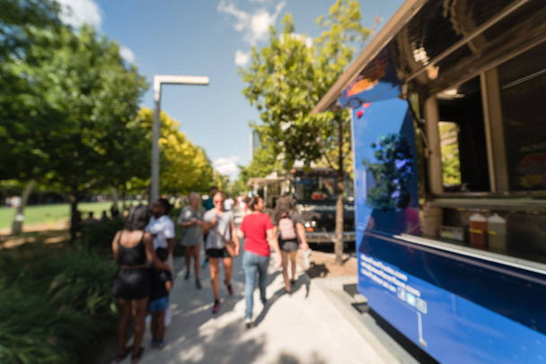 Abstracto movimiento borroso comida camión vendedor clientes compran y degustan variedad de alimentos. Gente esperando, haciendo cola para recoger comida y bebida en el parque urbano de Dallas, Texas, EE. UU., cielo azul
 - Foto, Imagen