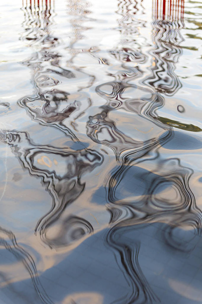 Reflejos en el agua del lago reflejando formas y el cielo
. - Foto, Imagen