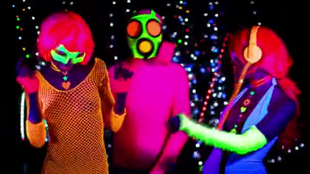 Mujeres y chico en máscara de gas en ropa fluorescente bajo luz negra UV
 - Metraje, vídeo
