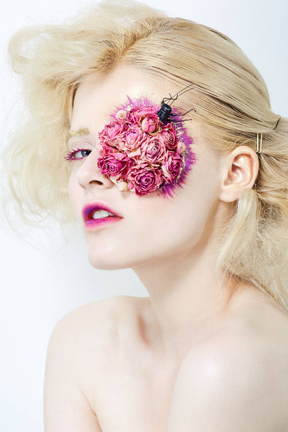 Blond meisje met bloemen op gezicht. - Foto, afbeelding