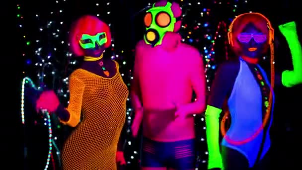Женщины и парень в противогазе в флуоресцентной одежде под ультрафиолетовым черным светом
 - Кадры, видео