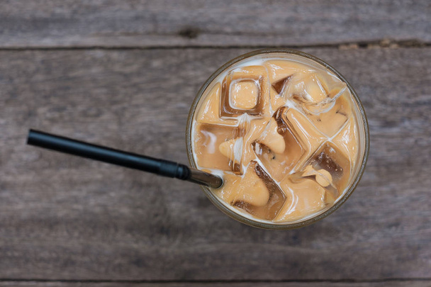 Cold coffee drink with ice on woodent table selective focus and copy space - Фото, изображение