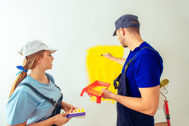 Adorable married couple doing home makeover with yellow color - Photo, Image