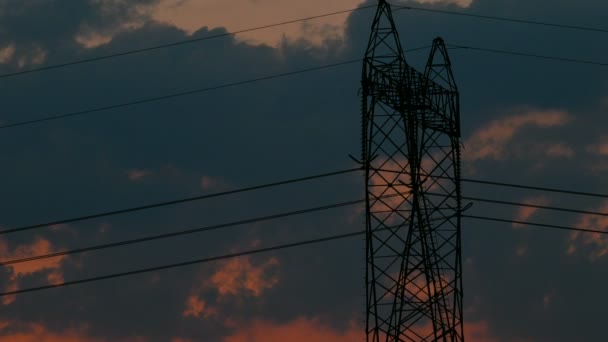 高電圧電気パイロン、夕日の塔、パイロン、4 k の後ろに移動する雲の時間経過のシルエット Uhd - 映像、動画
