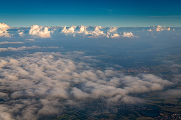 Vista desde la ventana del avión mostrando nubes y montañas en Europa central
. - Foto, imagen