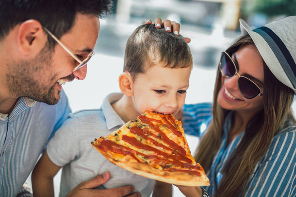 Портрет счастливой семьи, проводящей время в пиццерии
 - Фото, изображение