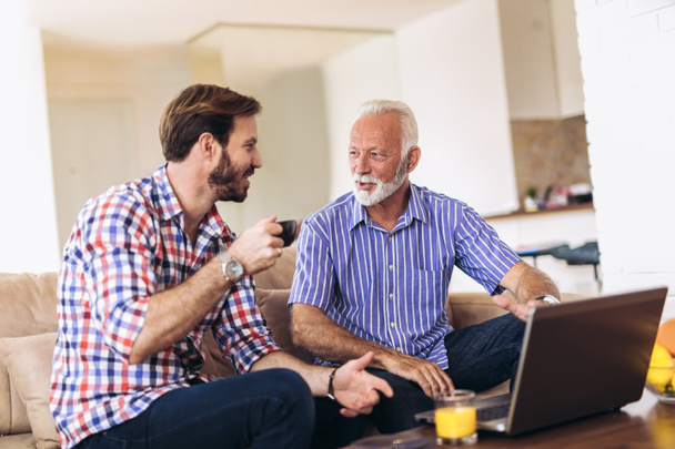 Adult Son Helping Senior Father With Computer At Home - Photo, Image