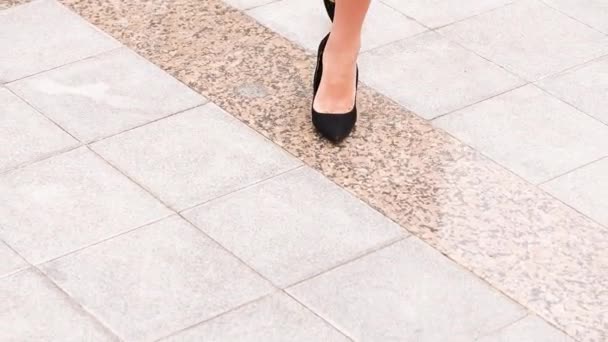 sexy Frauenbeine in schwarzen Stöckelschuhen auf der städtischen Straße. Schwebestativ stabilisierter Schuss, weibliche Beine in hochhackigen Schuhen, Nahaufnahme. Filmdreh - Filmmaterial, Video