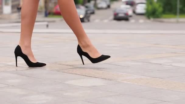 Γυναικεία πόδια με ψηλά τακούνια παπούτσια που περπατούν στον αστικό δρόμο. Πόδια νεαρής επιχειρηματία με ψηλοτάκουνα παπούτσια να πηγαίνουν στην πόλη. Κορίτσι που πηγαίνει στη δουλειά. Αργή κίνηση Κλείσιμο - Πλάνα, βίντεο