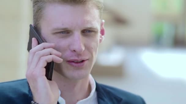 Young pensive businessman talking on the phone outdoors. - Felvétel, videó