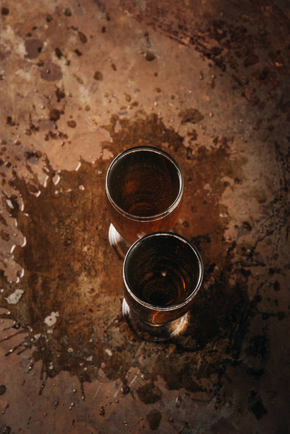 top view of glasses of cold beer on rust surface - Foto, immagini