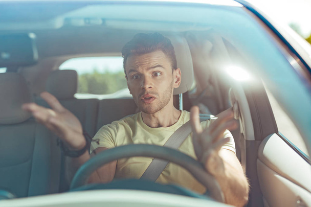 Angry emotional man driving his car without knowing the road - Photo, image
