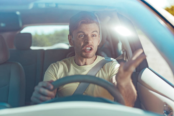 Emotional man feeling furious while driving near dangerous driver - Fotografie, Obrázek